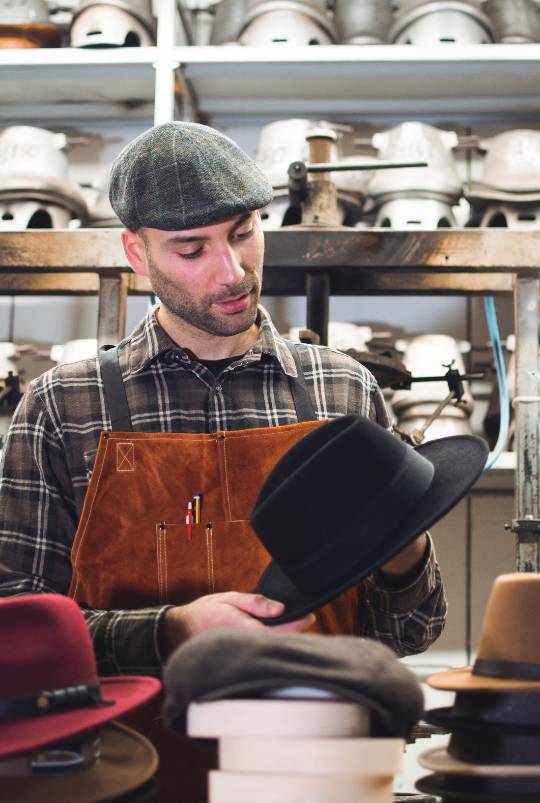 foto di Simone di Primario Nesti frontale che indossa coppole inglese e tiene in mano un cappello fedora in lana merinos