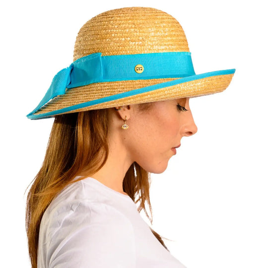 primo piano laterale di donna adulta con capelli lunghi che indossa un cappello con fiocco in paglia di firenze color treccia scura realizzato da primario nesti