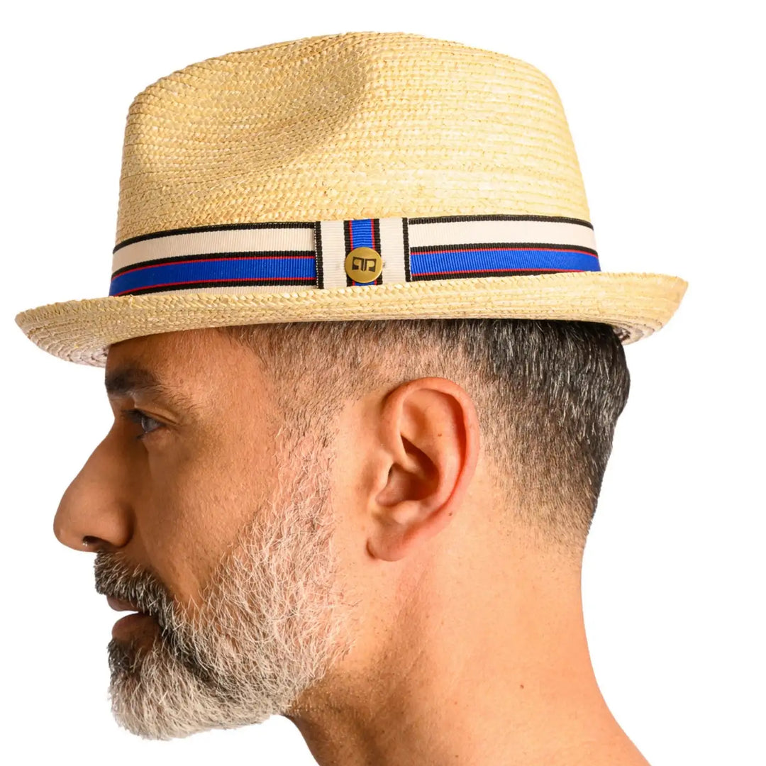 vista laterale di un uomo con barba che indossa un cappello da mare in paglia di firenze color treccia chiara fatto a mano da cappelleria primario nesti