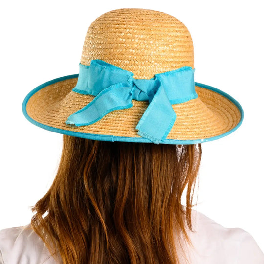 vista posteriore di una donna con capelli lunghi che indossa un cappello con fiocco in paglia di firenze color treccia scura fatto a mano da primario nesti