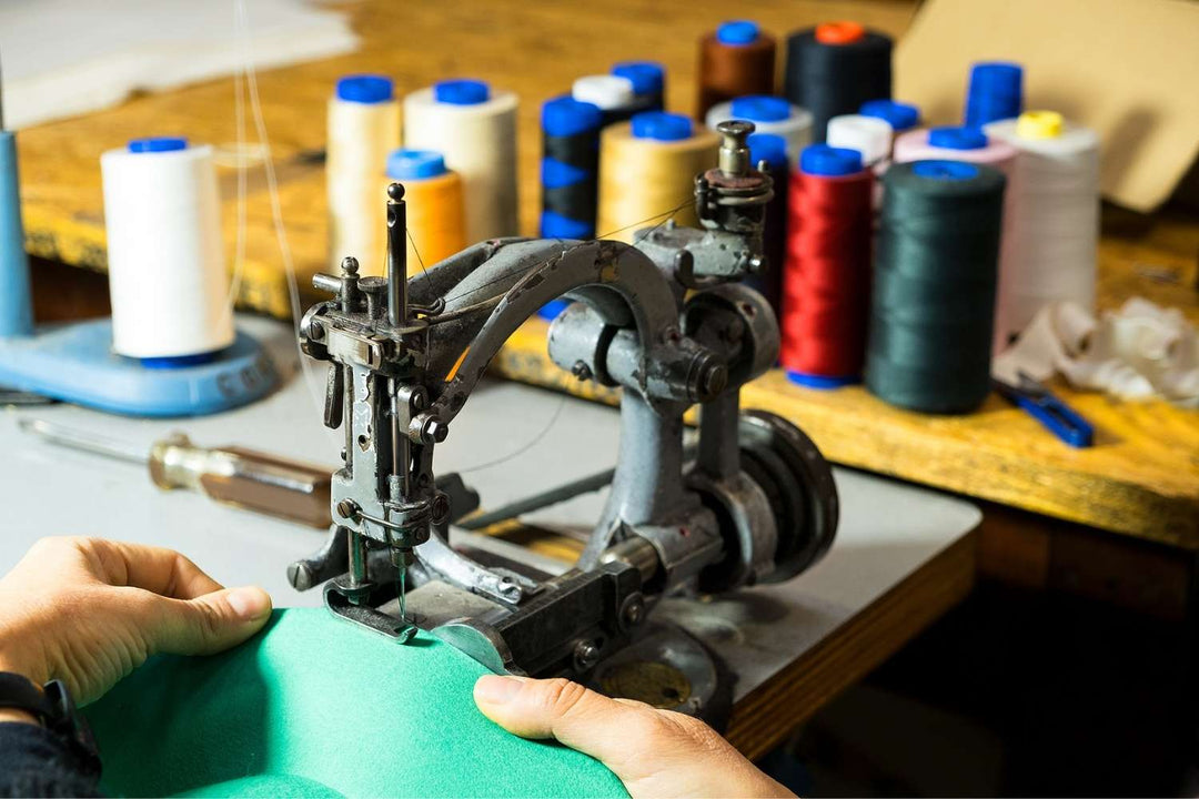 foto di una macchina da cucire del laboratorio di Primario Nesti, con rotoli di filo da cucire, usata come immagine di collegamento alla pagina "come lavoriamo"