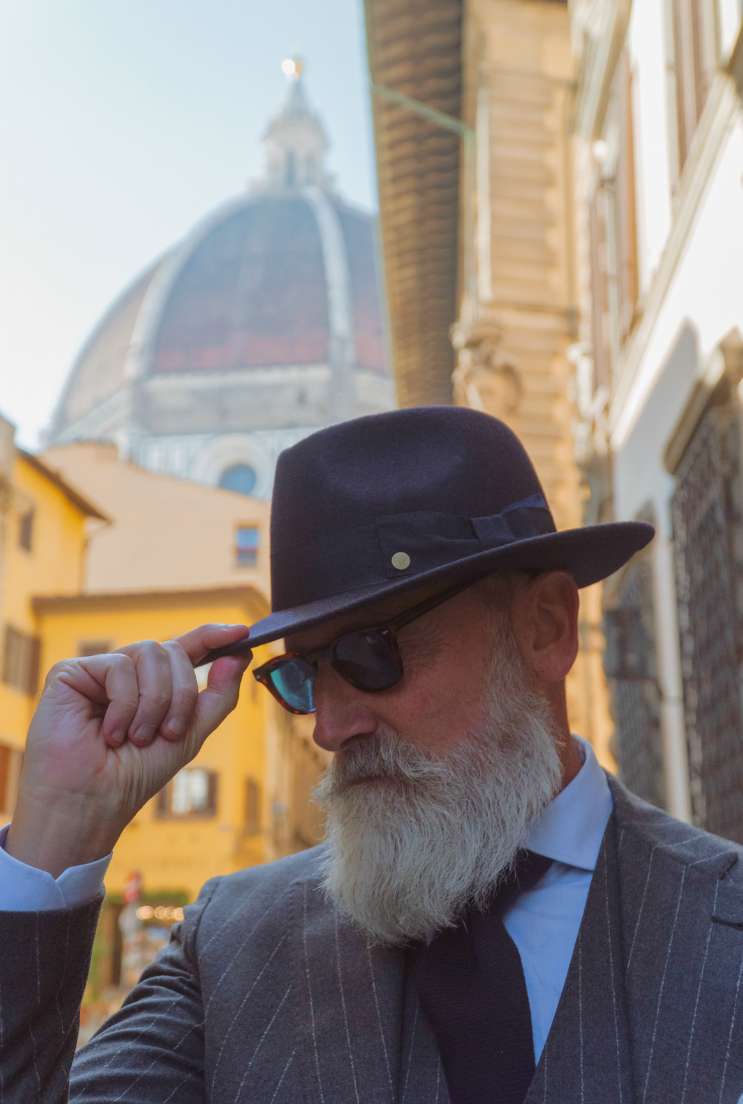 foto di Iuri, il modello gentiluomo che indossa un cappello fedora coccos di Primario Nesti con il duomo di Firenze sullo sfondo