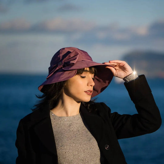 bucket impermeabile foderato in pile con fiocco primario nesti colore malva su modella veliero sullo sfondo perfetta fusione tra funzionalita e stile