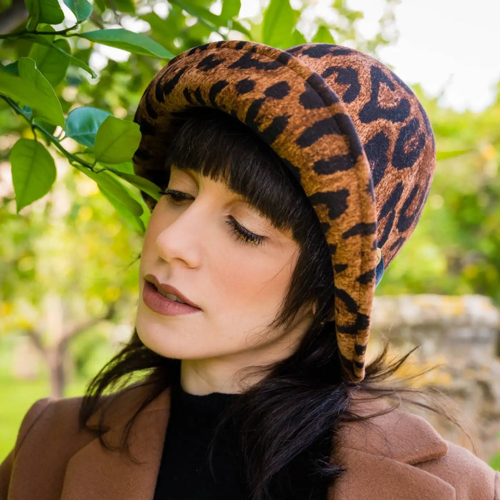 cappello a cloche ala rialzata animalier in feltro di lana merinos primario nesti ritratto modella tra vegetazione design sofisticato invernale