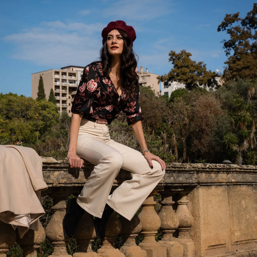 look casual chic con basco parigino in angora e lapin con ricamo floreale primario nesti bordeaux blusa floreale pose dinamica su balaustra