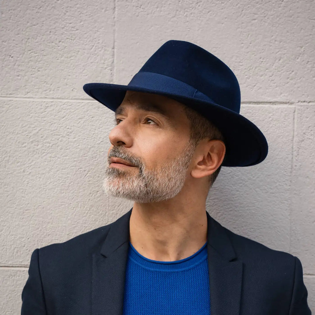 modello adulto con barba grigia indossa un cappello fedora in feltro di morbido cashmere primario nesti blu con il suo look ricercato