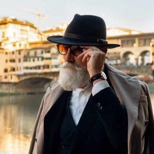 modello elegante con cappello fedora tradizionale primario nesti antipioggia nel suo look formale italiano ed una vista panoramica fiorentina al crepuscolo