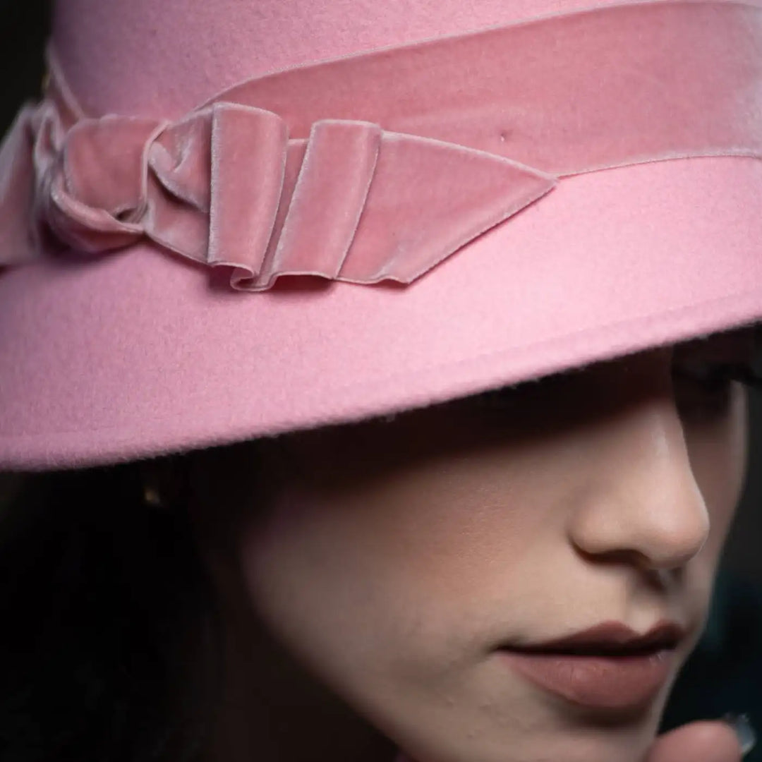 primo piano drammatico del cappello a cloche in feltro di lana merinos con nastro di velluto primario nesti rosa ispirazione anni 20 contemporanea