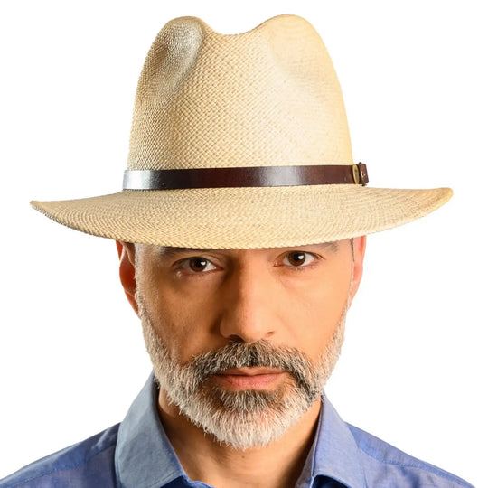 primo piano frontale di un uomo con barba che indossa un cappello di panama a tesa media da sole color bianco realizzato da cappelleria primario nesti