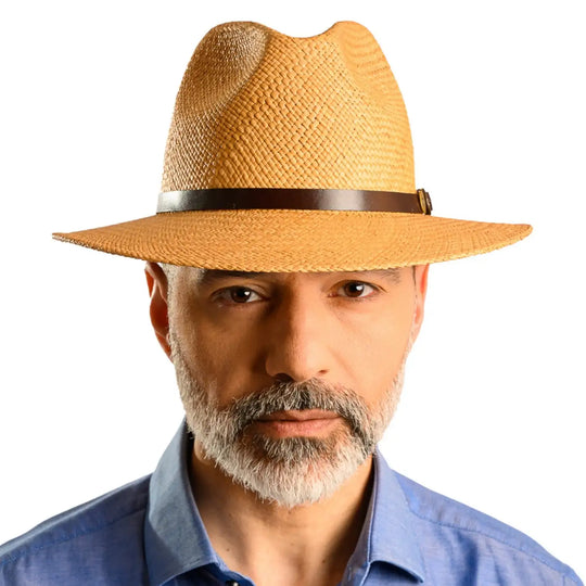 primo piano frontale di uomo con barba che indossa un cappello di panama a tesa media da sole color avana fatto da cappelleria primario nesti
