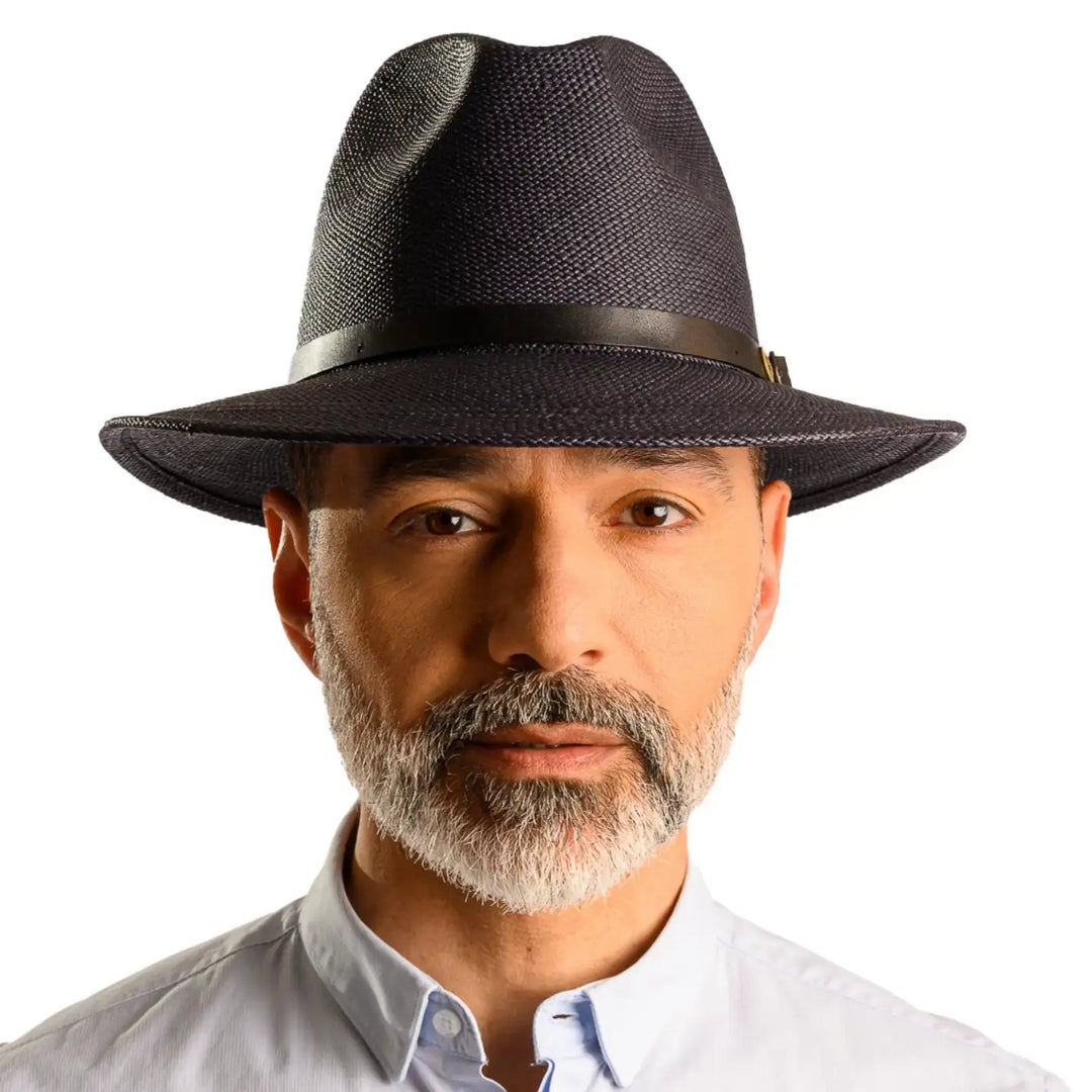 primo piano frontale di uomo con barba che indossa un cappello di panama a tesa media da sole color blu fatto da cappelleria primario nesti