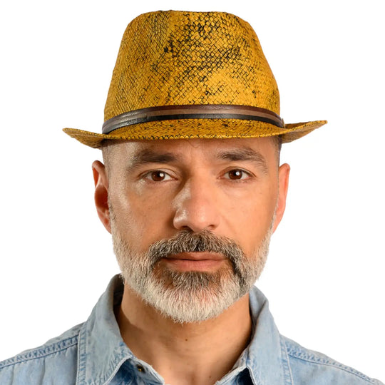 primo piano frontale di uomo con barba che indossa un cappello trilby a tesa corta stonewashed color ocra fatto da cappelleria primario nesti