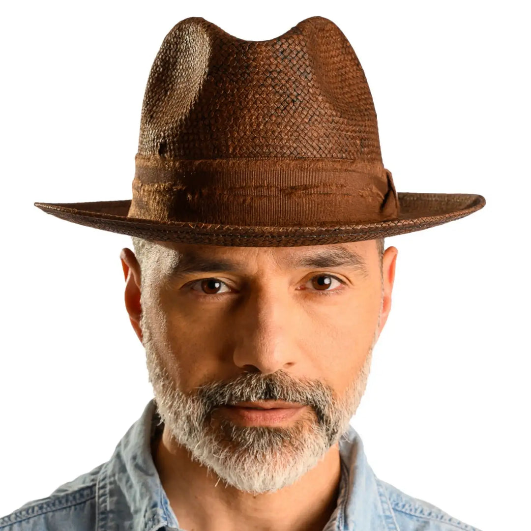 primo piano frontale di uomo con barba che indossa un cappello trilby a tesa media stonewashed color marrone fatto da cappelleria primario nesti