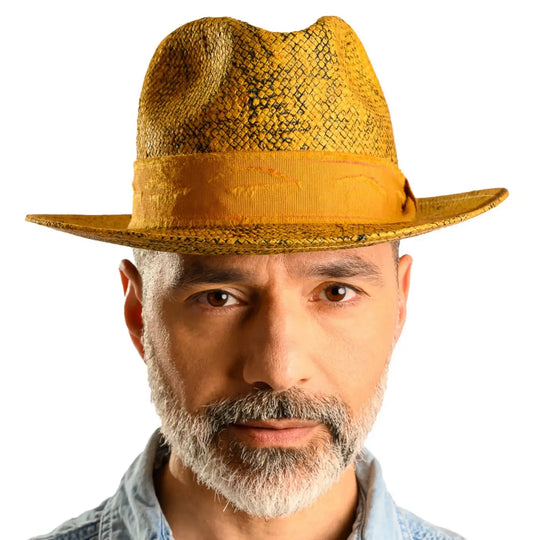 primo piano frontale di uomo con barba che indossa un cappello trilby a tesa media stonewashed color ocra fatto da cappelleria primario nesti