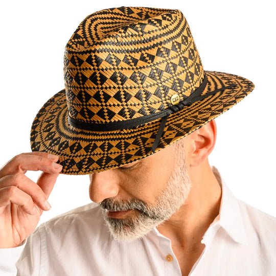 primo piano frontale inclinato di uomo con barba che indossa un cappello da mare a fantasia geometrica color avana nero fatto da cappelleria primario nesti