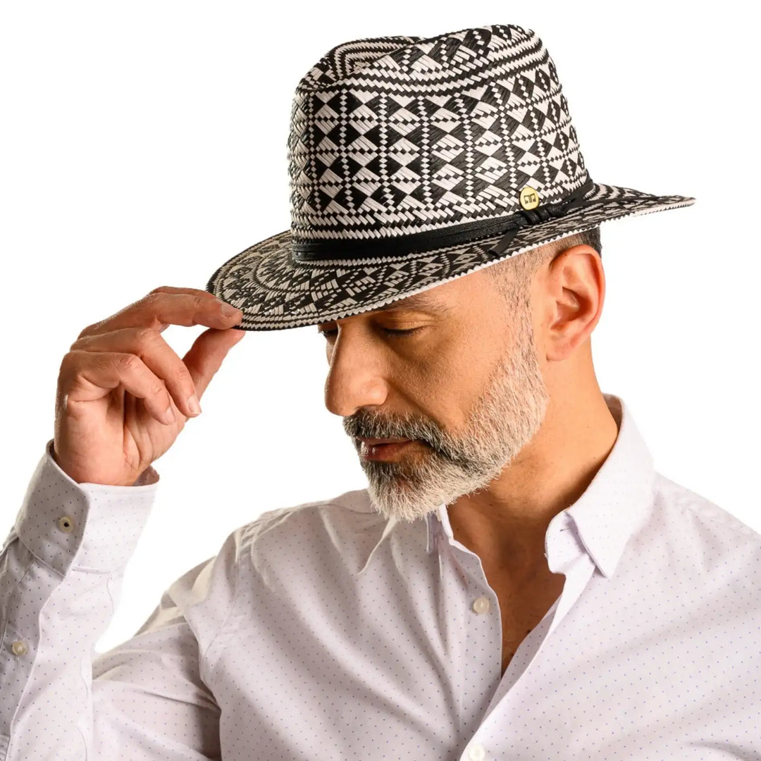 primo piano frontale inclinato di uomo con barba che indossa un cappello da mare a fantasia geometrica color bianco nero fatto da cappelleria primario nesti