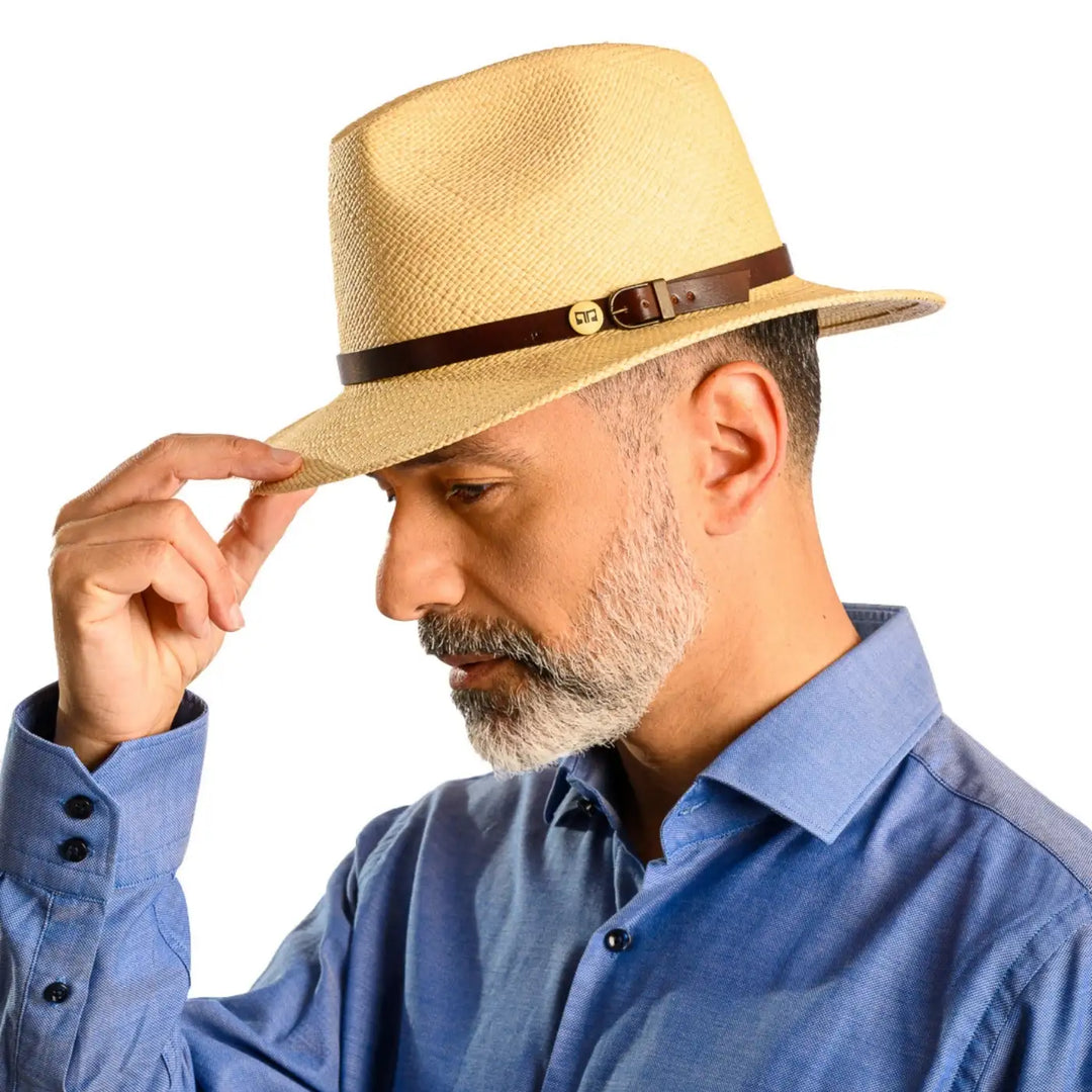 primo piano frontale inclinato di uomo con barba che indossa un cappello di panama a tesa media da sole color naturale fatto da cappelleria primario nesti