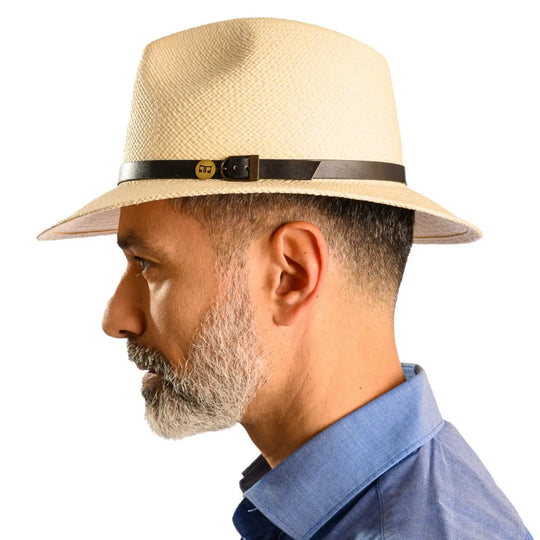 primo piano laterale di uomo con barba che indossa un cappello di panama a tesa media da sole color bianco fatto da cappelleria primario nesti