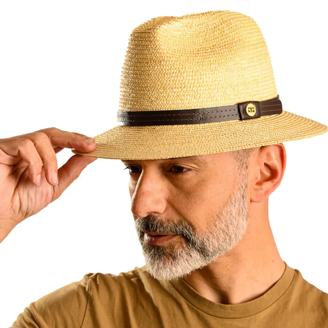 primo piano laterale inclinato di uomo con barba che indossa un cappello tesa media in paglia di firenze color treccia chiara realizzato da primario nesti