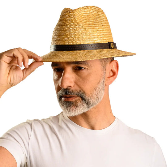 primo piano laterale inclinato di uomo con barba che indossa un cappello tesa media in paglia di firenze color treccia scura realizzato da primario nesti