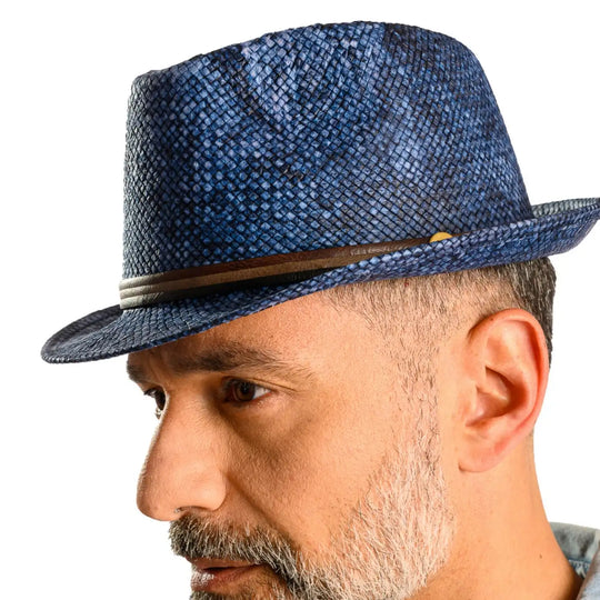 primo piano laterale inclinato di uomo con barba che indossa un cappello trilby a tesa corta stonewashed color jeans realizzato da primario nesti