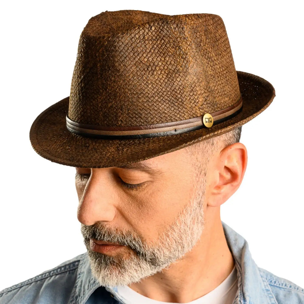 primo piano laterale inclinato di uomo con barba che indossa un cappello trilby a tesa corta stonewashed color marrone realizzato da primario nesti