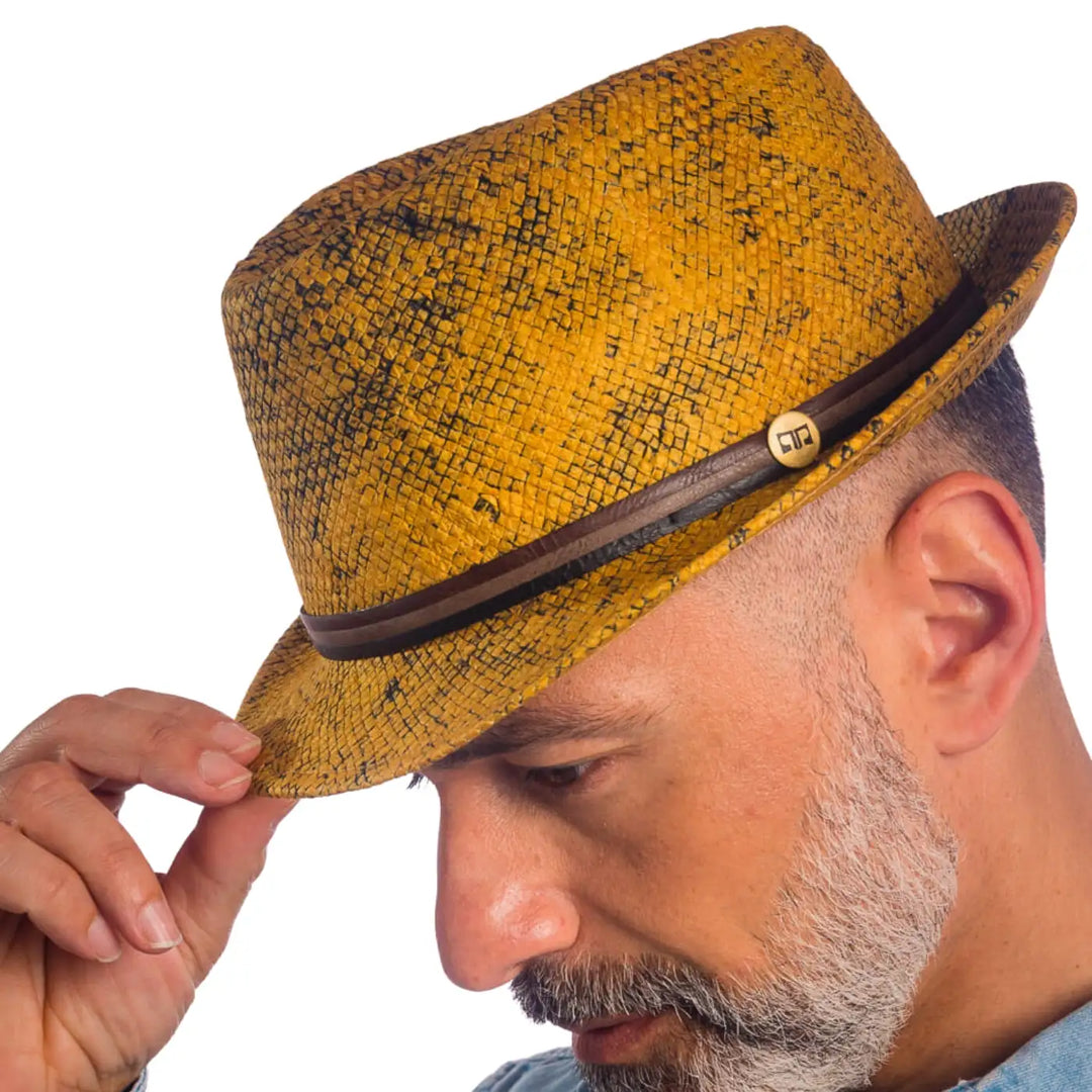 primo piano laterale inclinato di uomo con barba che indossa un cappello trilby a tesa corta stonewashed color ocra realizzato da primario nesti