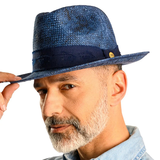 primo piano laterale inclinato di uomo con barba che indossa un cappello trilby a tesa media stonewashed color jeans realizzato da primario nesti