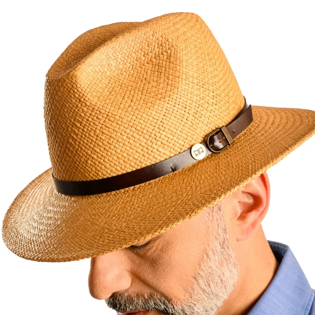 primo piano laterale ravvicinato di uomo con barba che indossa un cappello di panama a tesa media da sole color avana realizzato da primario nesti