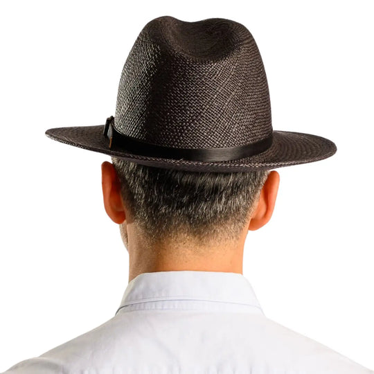 primo piano posteriore di uomo con barba che indossa un cappello di panama a tesa media da sole color nero fatto da cappelleria primario nesti