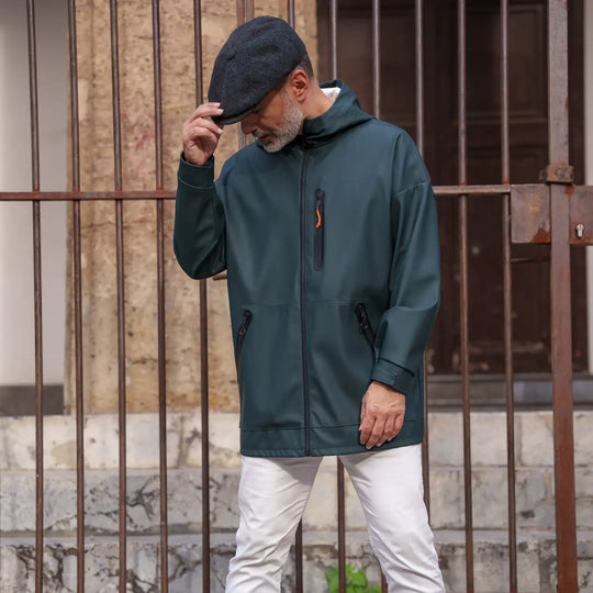 uomo contemporaneo con coppola peaky blinders newsboy primario nesti giacca tecnica verde pantalone bianco look sportivo chic