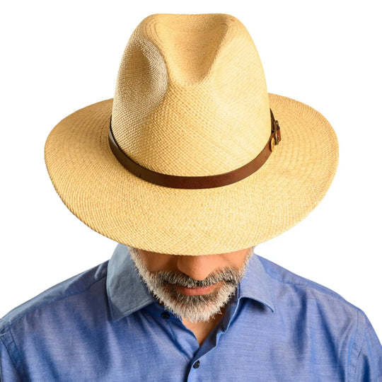 vista frontale abbassata di un uomo con barba che indossa un cappello di panama a tesa media da sole color naturale fatto a mano da cappelleria primario nesti