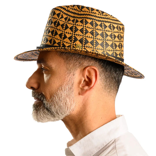 vista laterale di un uomo con barba che indossa un cappello da mare a fantasia geometrica color avana nero fatto a mano da cappelleria primario nesti