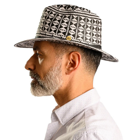 vista laterale di un uomo con barba che indossa un cappello da mare a fantasia geometrica color bianco nero fatto a mano da cappelleria primario nesti
