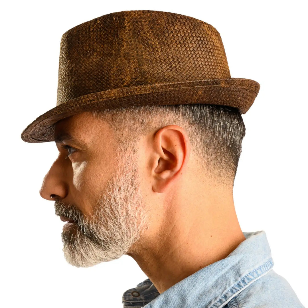 vista laterale di un uomo con barba che indossa un cappello trilby a tesa corta stonewashed color marrone fatto a mano da cappelleria primario nesti