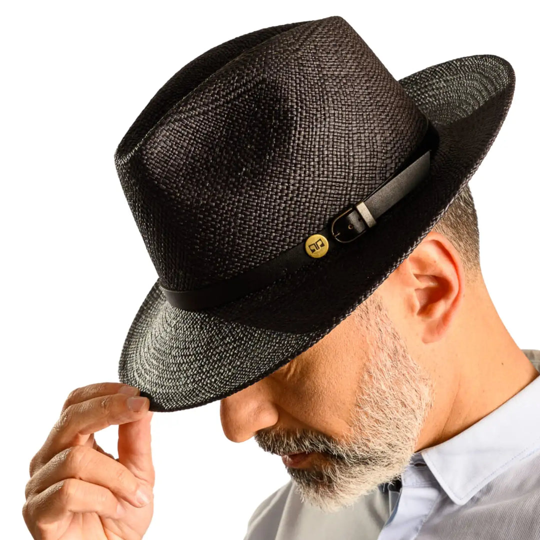 vista laterale inclinata di un uomo con barba che indossa un cappello di panama a tesa media da sole color nero fatto a mano da cappelleria primario nesti