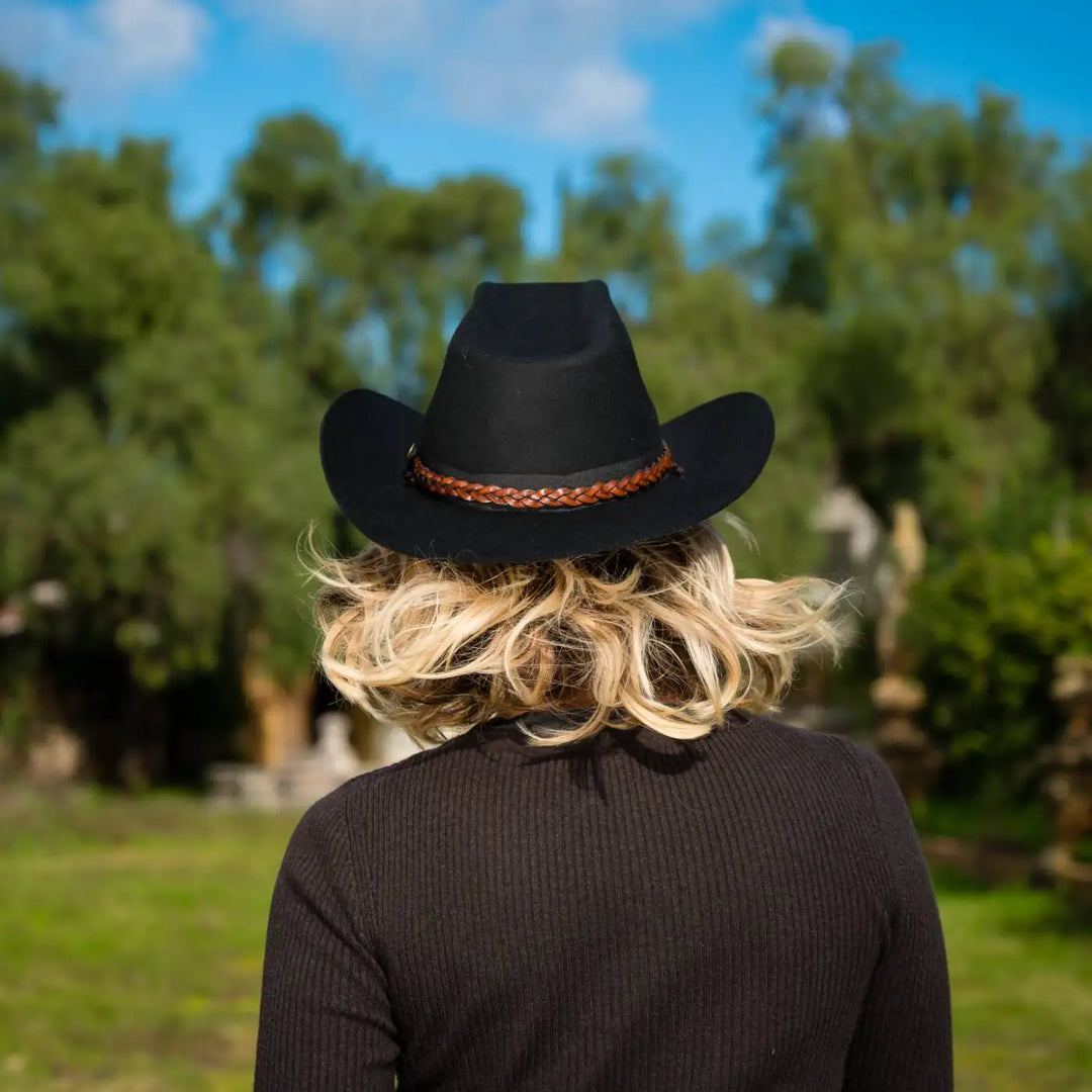 vista posteriore cappello da cowboy in feltro di lana merinos antipioggia primario nesti nero modella bionda in ambiente naturale design raffinato