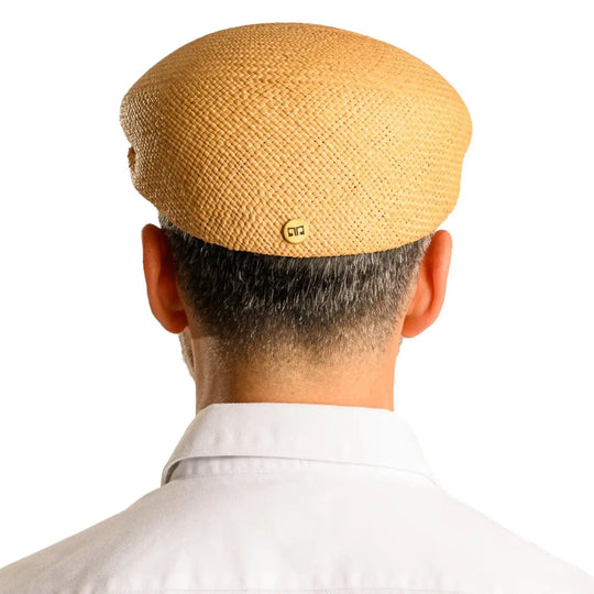 vista posteriore di un uomo con barba che indossa un coppola siciliana estiva di panama color avana fatto a mano da cappelleria primario nesti